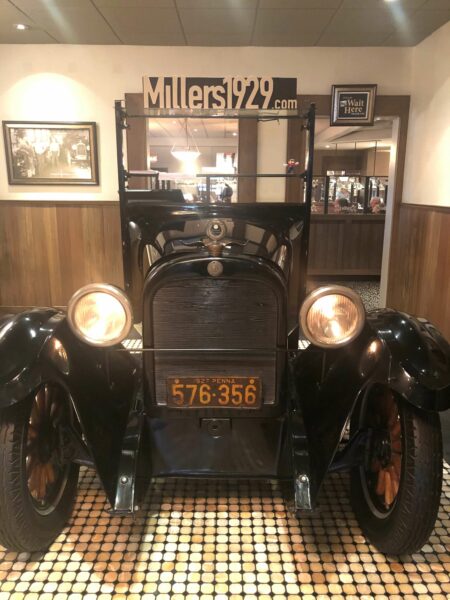 Old fashioned car on display in restaurant.