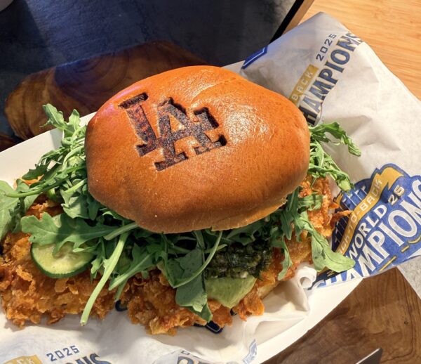 Chicken sandwich in a bun marked with LA Dodgers logo.