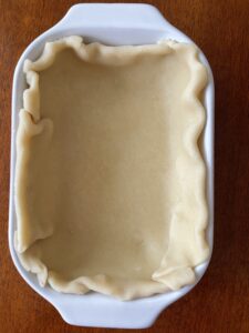Pie dough circle pressed into rectangular pan.