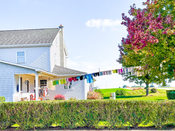 Farmhouse with a string of rainbow colored laundry.