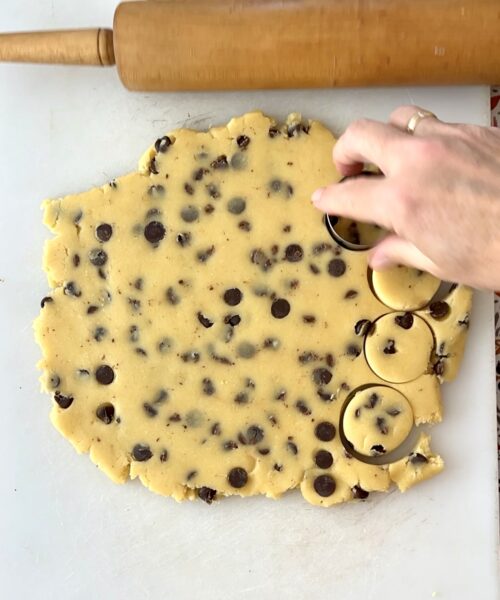 Cookie dough with cookie cutter cutting into little circles.