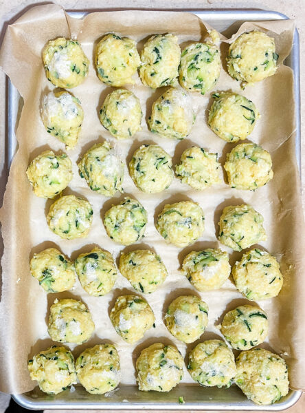 Frozen zucchini meatballs on a tray.