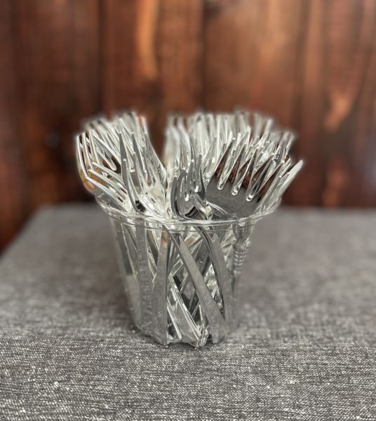 Cup filled with tiny forks for grazing table.