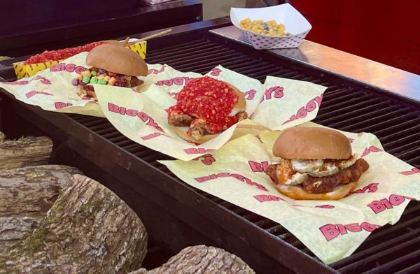 Three Biggy's chicken sandwiches lined up on a gril.