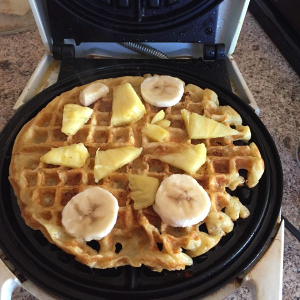 Just place the pineapple and bananas on the waffle when it is halfway finished with the cooking process...then sprinkle on a little brown sugar so it caramelizes. 
